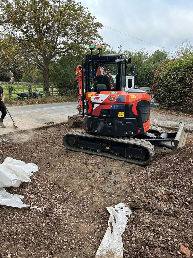 Mini digger excavating a driveway down to firm ground